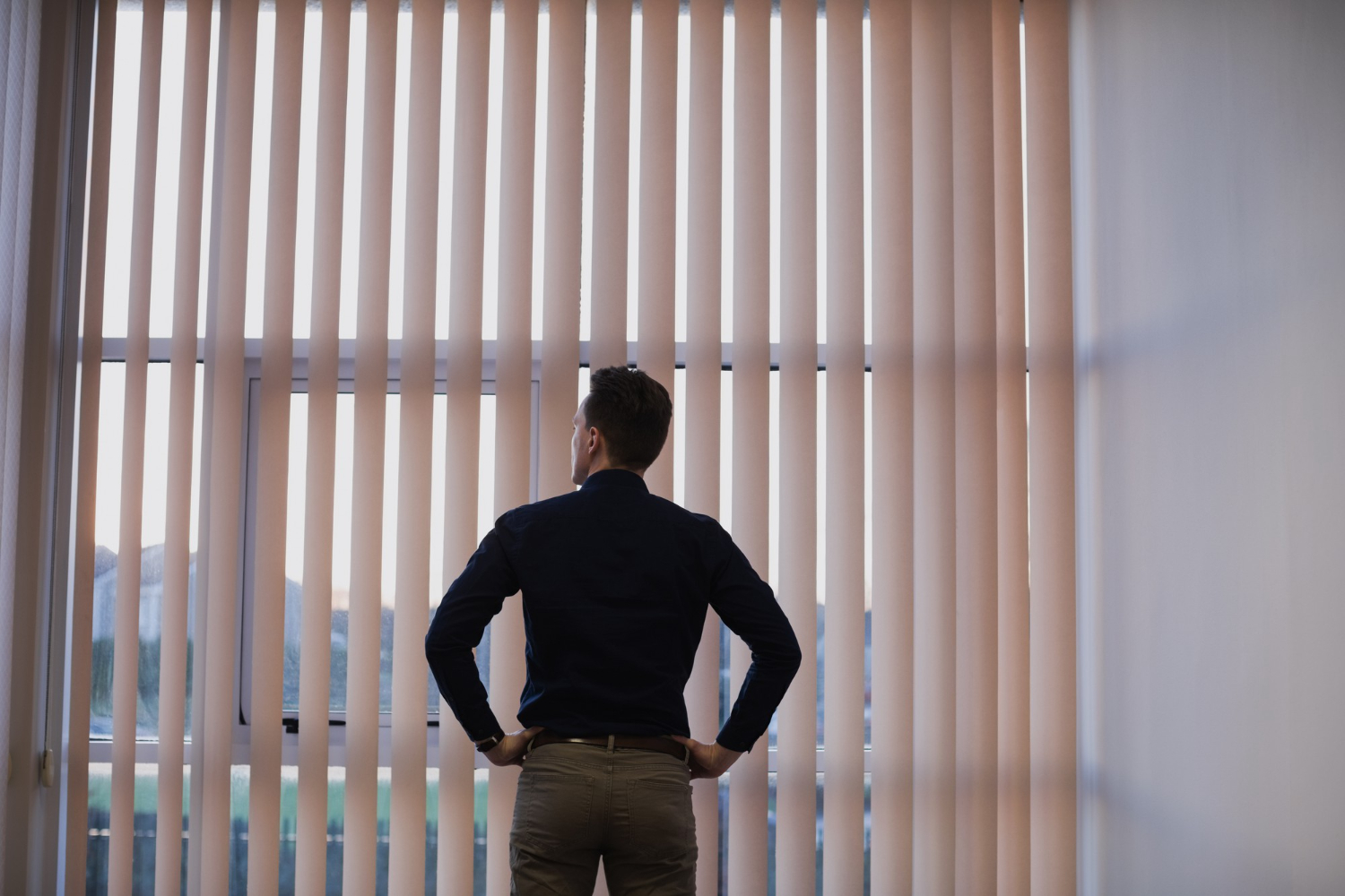 woman admiring roller blinds on a window from curtain and blinds co who sells blinds online in UAE